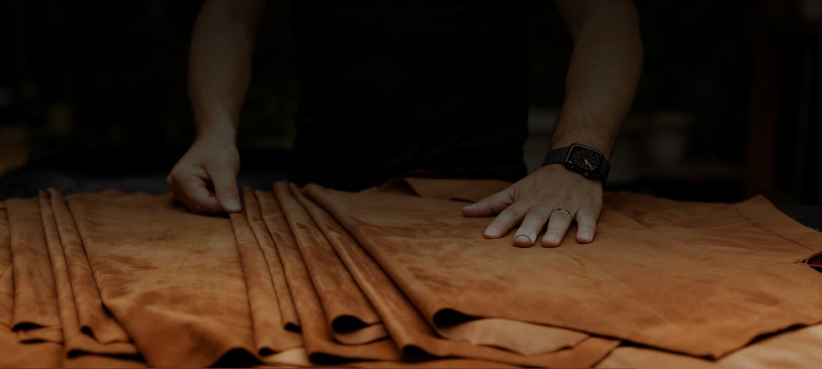 A hand working the leather before cutting